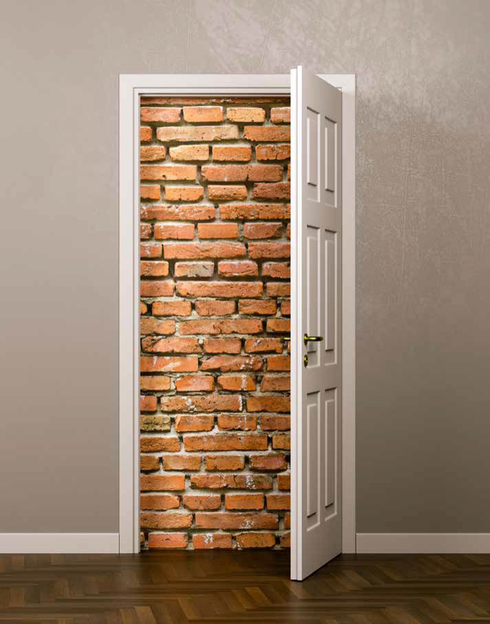 A imagem mostra uma parede cinza com uma porta branca entreaberta. Após essa porta entreaberta, existe uma parede de tijolos do chão até o teto, impedindo completamente a passagem.